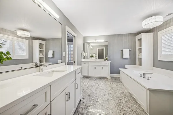 a large bathroom with a double vanity sink a mirror and a bathtub