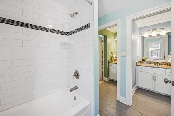 a bathroom with a tub a sink and a mirror