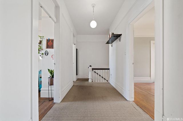 a view of a hallway with closet and wooden floor