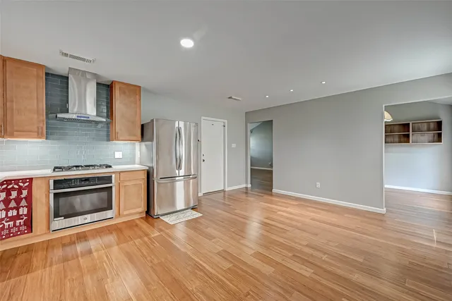 a kitchen with granite countertop a refrigerator and a stove top oven