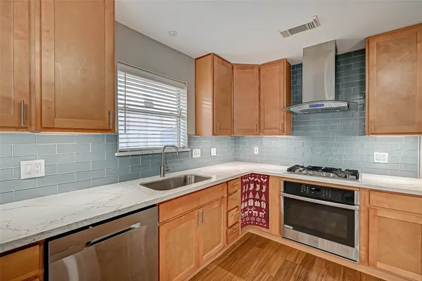a kitchen with granite countertop a sink a stove and cabinets