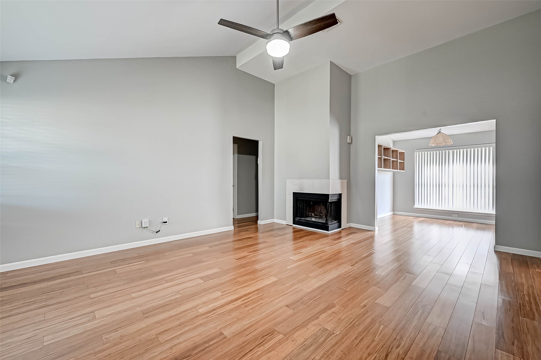 9466 Coast Bridge Street Houston, TX 77075 - Photo 6 of 29 an empty room with wooden floor fireplace and windows