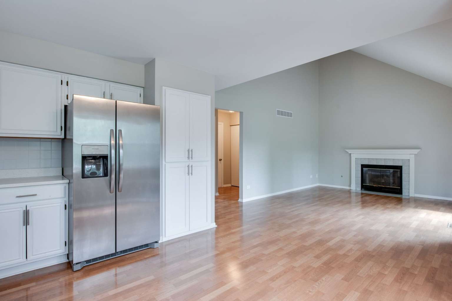 2203 Riverside Drive Plainfield, IL 60586 - Photo 8 of 25 a view of an empty room with wooden floor and a kitchen