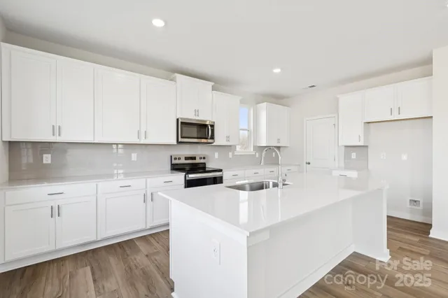 a kitchen with sink a microwave and cabinets