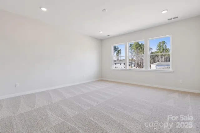 an empty room with windows and mirror