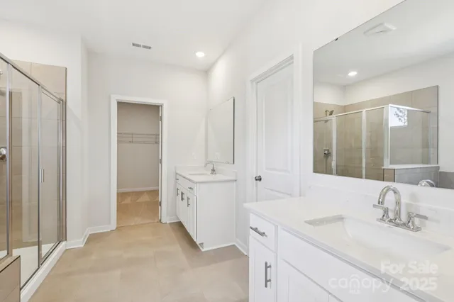 a spacious bathroom with a double vanity sink and a mirror
