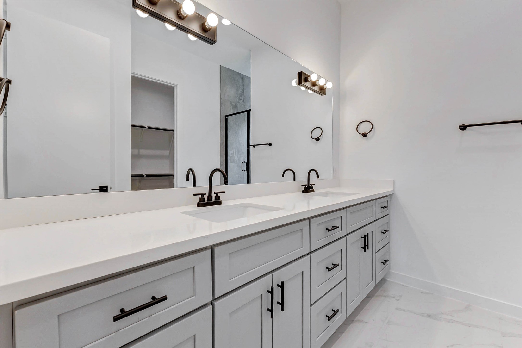 6017 Beall Street Houston, TX 77091 - Photo 16 of 33 Sophisticated simplicity defines this dual-sink vanity with ample drawer storage, matte black fixtures, and full-width mirror perfectly complementing the en-suite’s clean and modern aesthetic.
