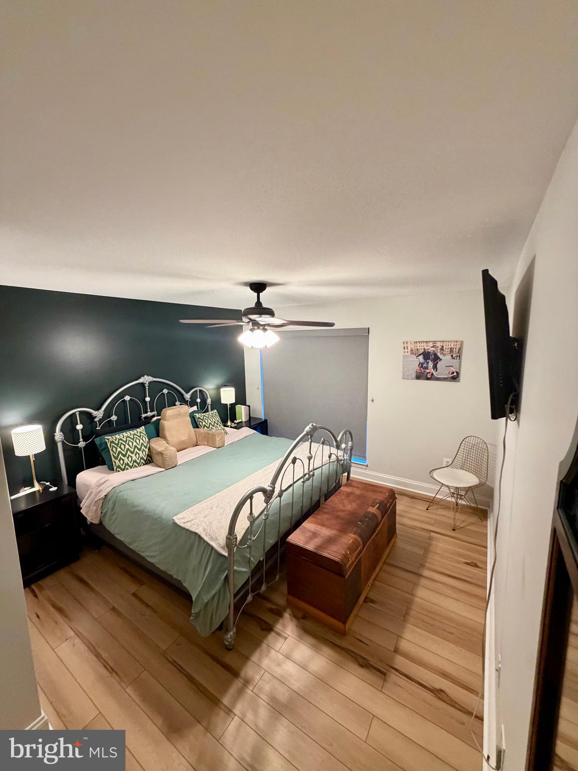 100 North 22nd Street, Unit 106 Philadelphia, PA 19103 - Photo 14 of 26 a bedroom with a bed and a flat tv screen on a dresser