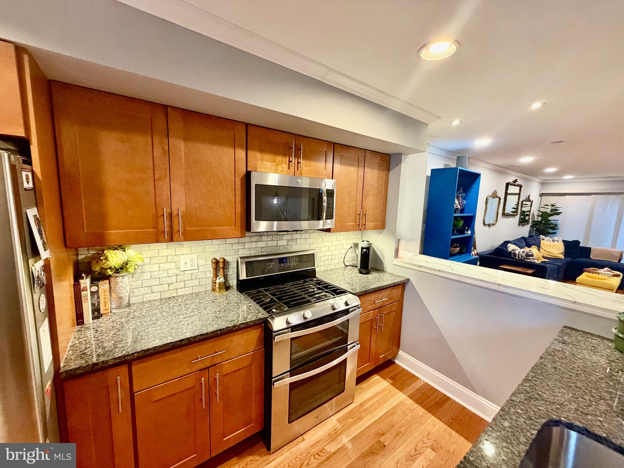 100 North 22nd Street, Unit 106 Philadelphia, PA 19103 - Photo 7 of 26 a kitchen with stainless steel appliances granite countertop a sink stove microwave and refrigerator