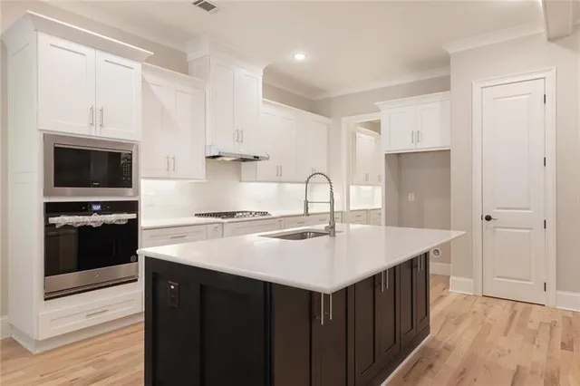 a view of a kitchen with white cabinets