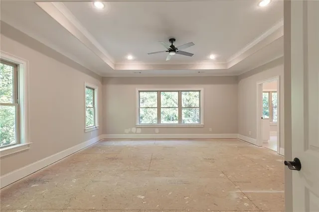 an empty room with fan and windows