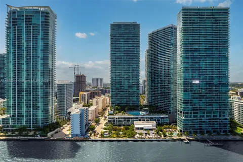 an empty room with windows and ceiling fan