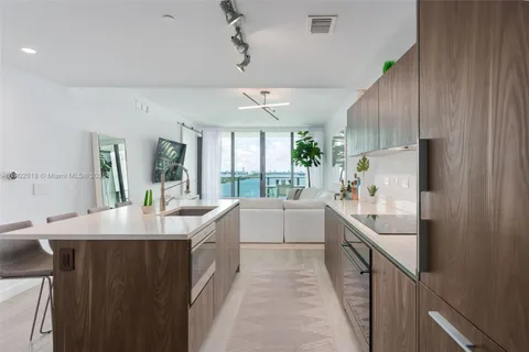 a large white kitchen with a large window