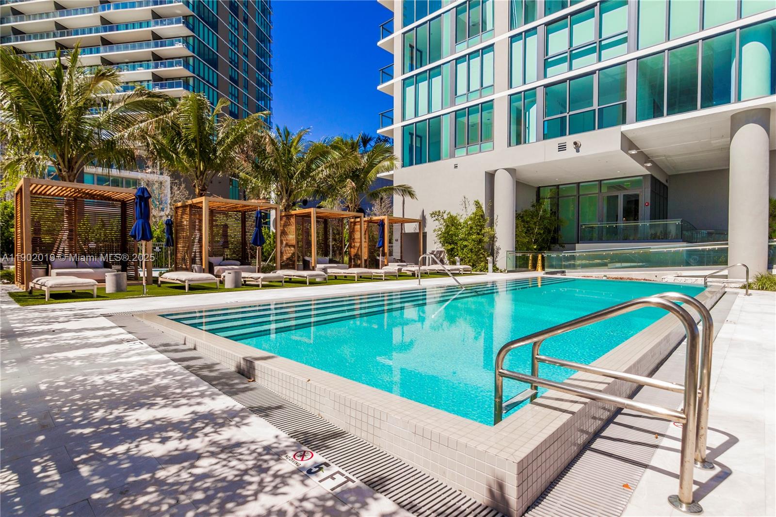 3131 Northeast 7th Avenue, Unit 2202 Miami, FL 33137 - Photo 49 of 68 a view of a swimming pool with a lounge chairs
