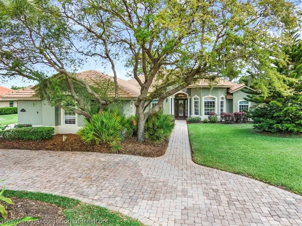 a front view of a house with a yard and potted plants