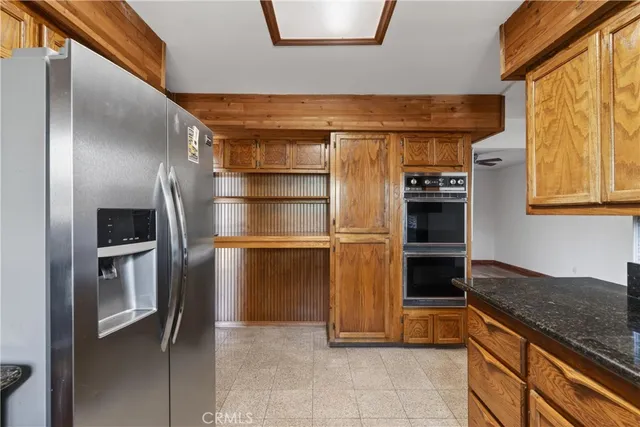 a kitchen with stainless steel appliances granite countertop a refrigerator and a sink