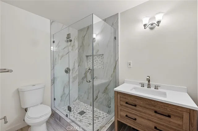 a bathroom with a shower a sink a toilet and a mirror