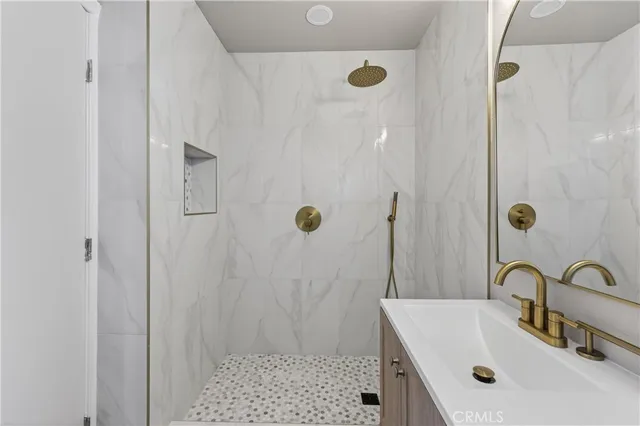 a bathroom with a sink a shower and a mirror