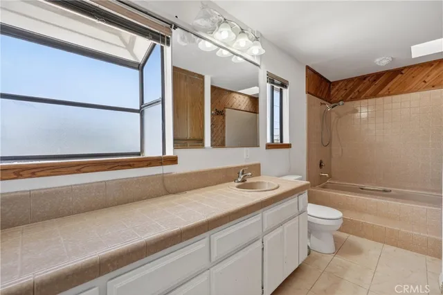 a bathroom with a double vanity sink toilet mirror and shower