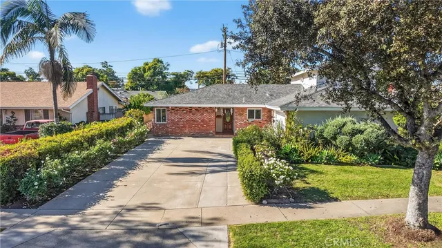 a view of a house with a yard and potted plants