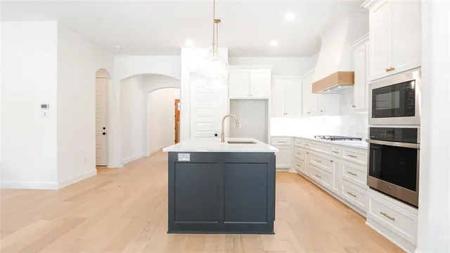 a kitchen with stainless steel appliances kitchen island granite countertop a sink stove and refrigerator