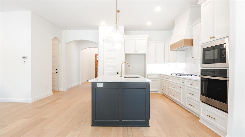 427 Wingtail Drive Aledo, TX 76008 - Photo 3 of 13 a kitchen with stainless steel appliances kitchen island granite countertop a sink stove and refrigerator