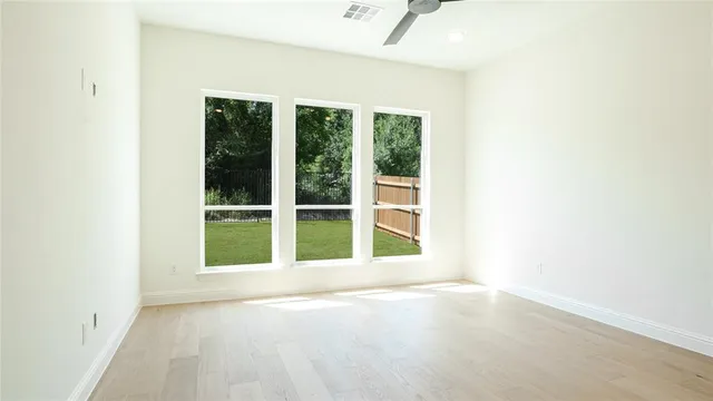 a large room with kitchen view and a chandelier fan
