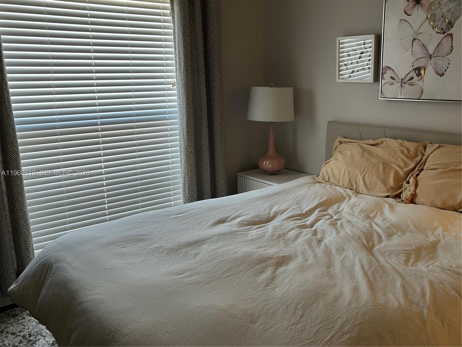 5555 Ludlam Road, Unit 501 South Miami, FL 33155 - Photo 12 of 20 a large white bed in a bedroom next to a window