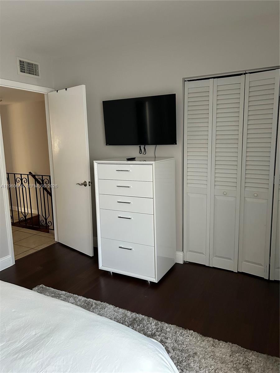 5555 Ludlam Road, Unit 501 South Miami, FL 33155 - Photo 13 of 20 a view of bedroom with furniture and flat screen tv