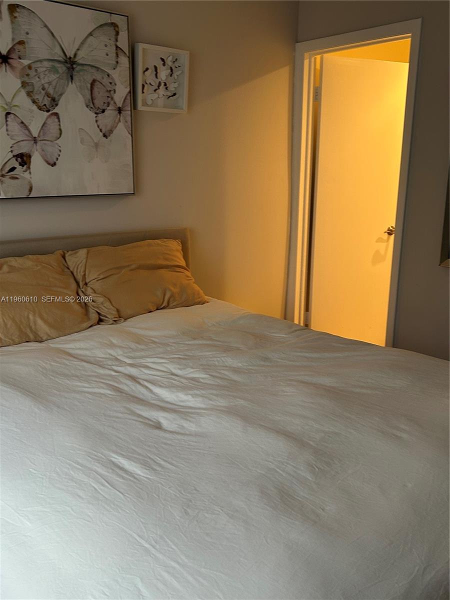 5555 Ludlam Road, Unit 501 South Miami, FL 33155 - Photo 15 of 20 a bedroom with a large bed and a window