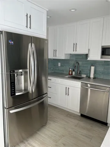 a kitchen with granite countertop white cabinets and white appliances