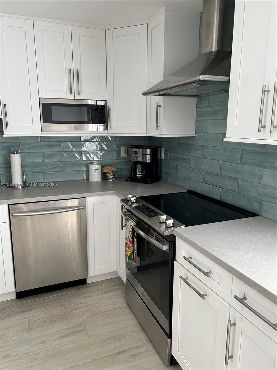 5555 Ludlam Road, Unit 501 South Miami, FL 33155 - Photo 5 of 20 a kitchen with granite countertop white cabinets and white appliances