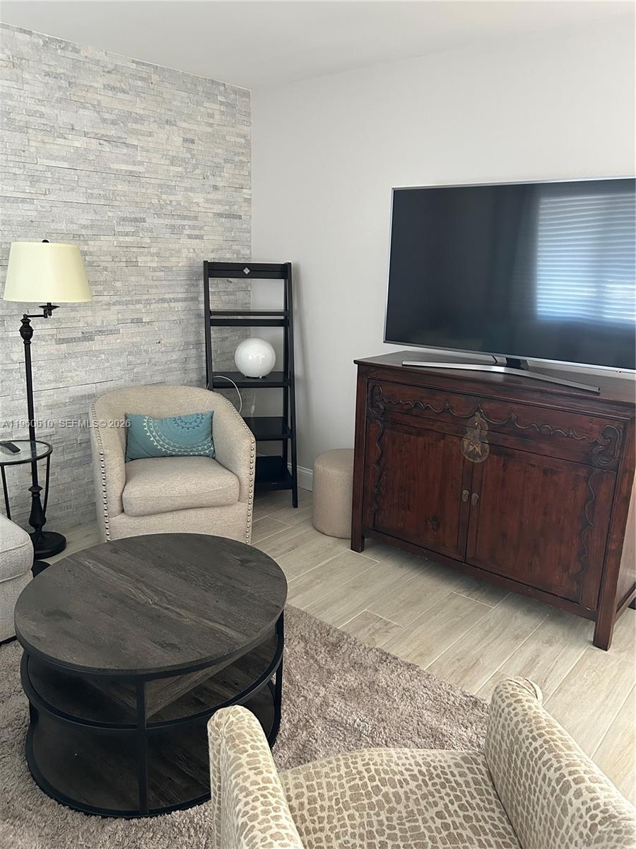 5555 Ludlam Road, Unit 501 South Miami, FL 33155 - Photo 6 of 20 a living room with furniture and a flat screen tv