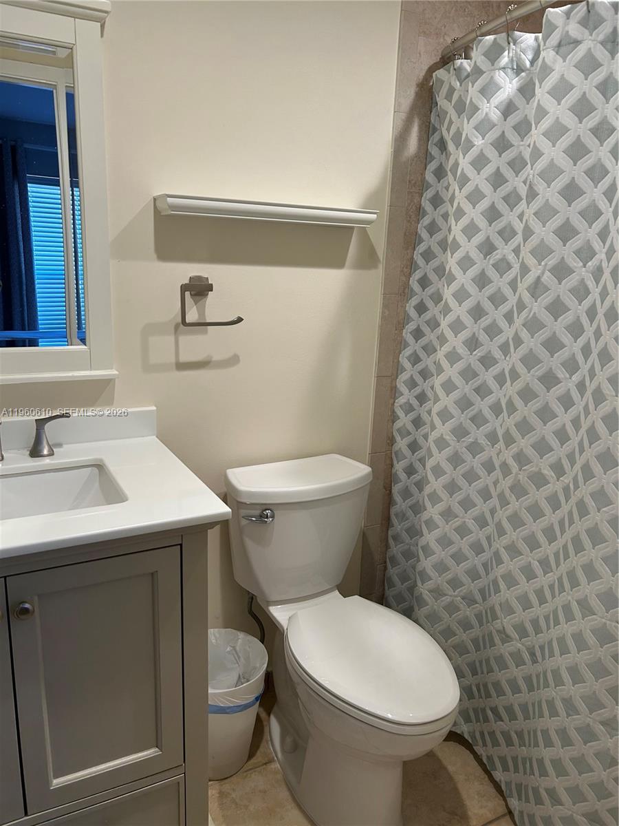 5555 Ludlam Road, Unit 501 South Miami, FL 33155 - Photo 10 of 20 a bathroom with a sink a toilet and a mirror