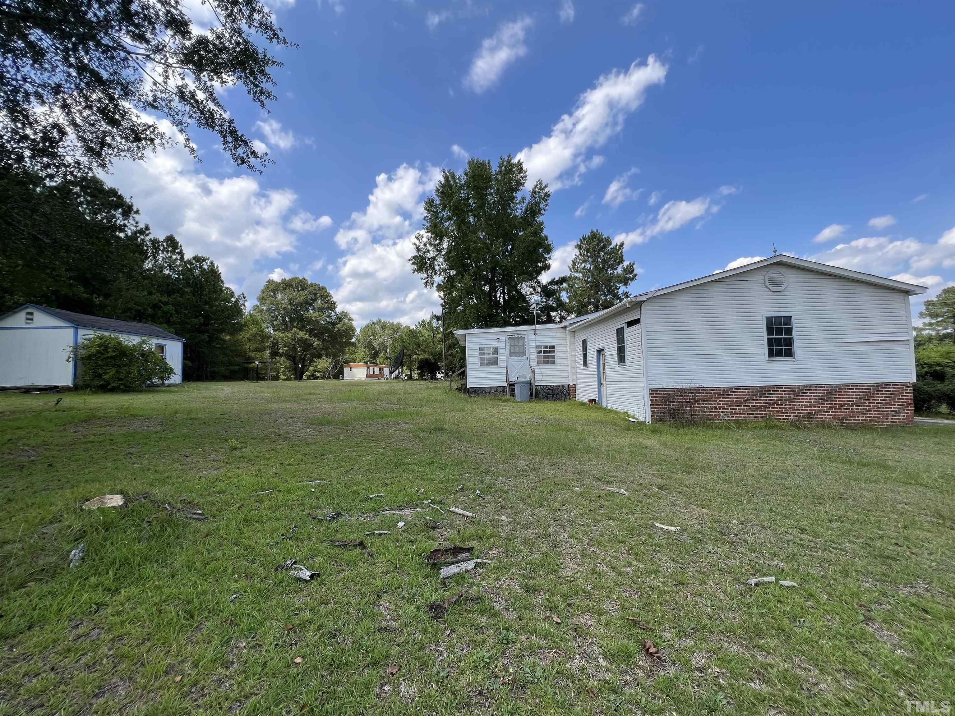 772 Nutgrass Road Bunnlevel, NC 28323 - Photo 2 of 6 a backyard of a house with plants and large tree