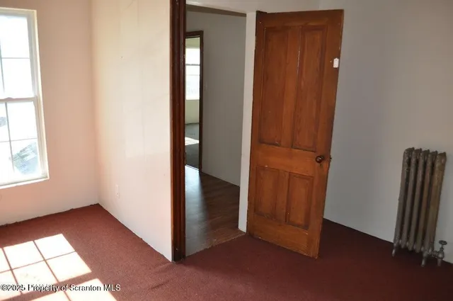 an empty room with windows and closet