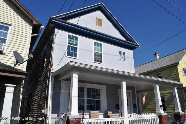 a front view of a residential apartment building with a small garden