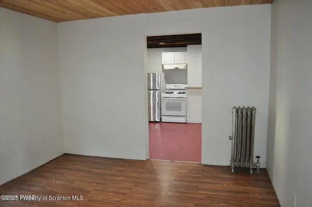 a view of empty room with wooden floor