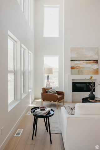 5902 Canyon Rim Road, Unit 620 Lehi, UT 84048 - Photo 32 of 78 Two-story living area featuring a fireplace with a black firebox, multiple large windows, wood-finish flooring, and crisp white walls