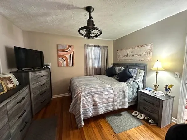 a bedroom with a bed and wooden floor