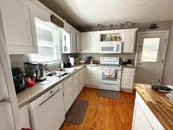 a kitchen with a sink a window stainless steel appliances and cabinets