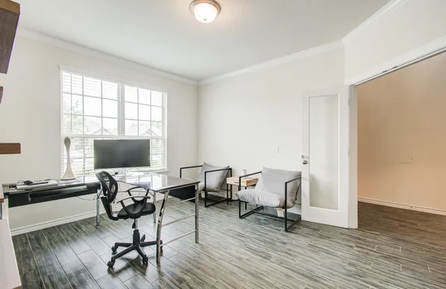 a workspace with wooden floor and a window