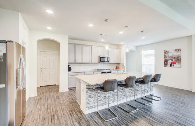 a kitchen with stainless steel appliances granite countertop a stove and a wooden floors