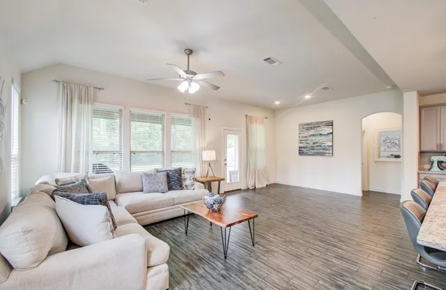 a living room with furniture and wooden floor