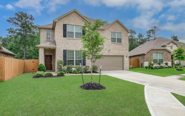 a front view of a house with a yard and trees