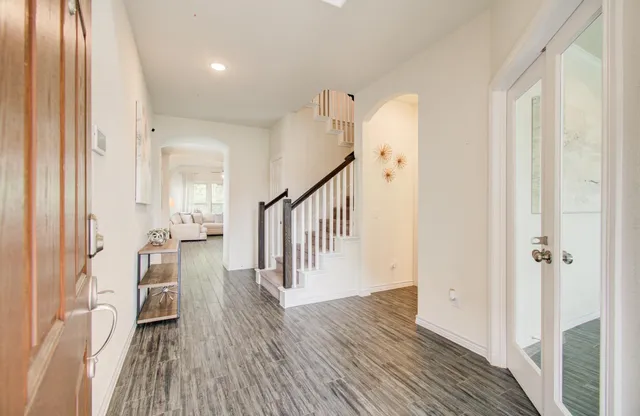 a view of a hallway with wooden floor and staircase