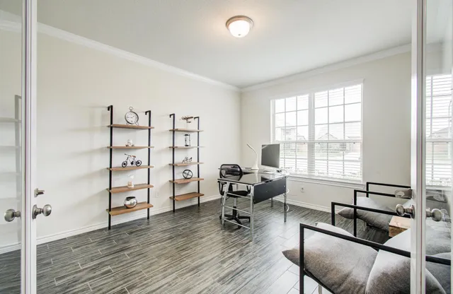 a view of a livingroom with workspace and a window