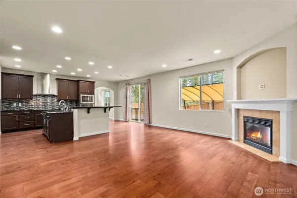 a view of kitchen with kitchen island granite countertop a stove top oven a sink and a counter top space