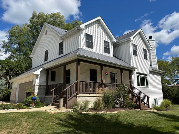 a front view of a house with a yard and trees