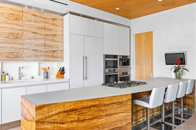 a room with kitchen island and stainless steel appliances
